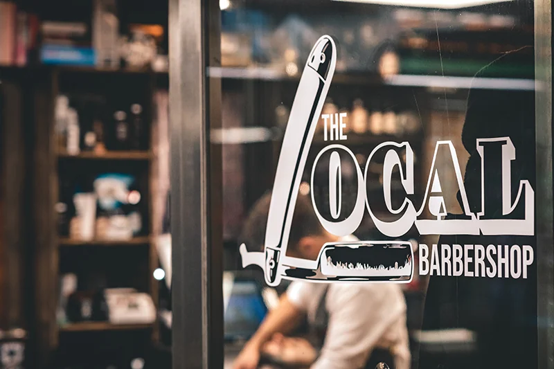 The Local Barbershops logotyp på salongens skyltfönster